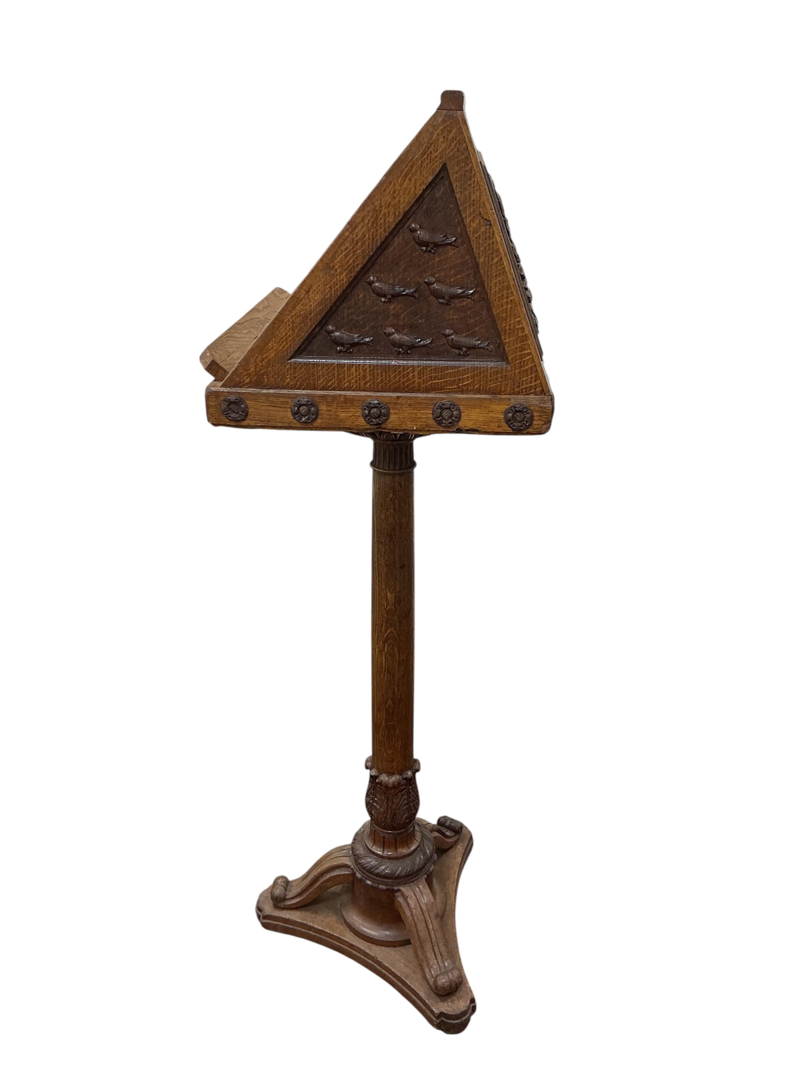 A mid 20th century oak lectern carved with ribbon fold floral swag and the legend “Rolfe George Martin, M.A (Cantab), First Headmaster of The School, 1924 - 1947. Height 142cm.